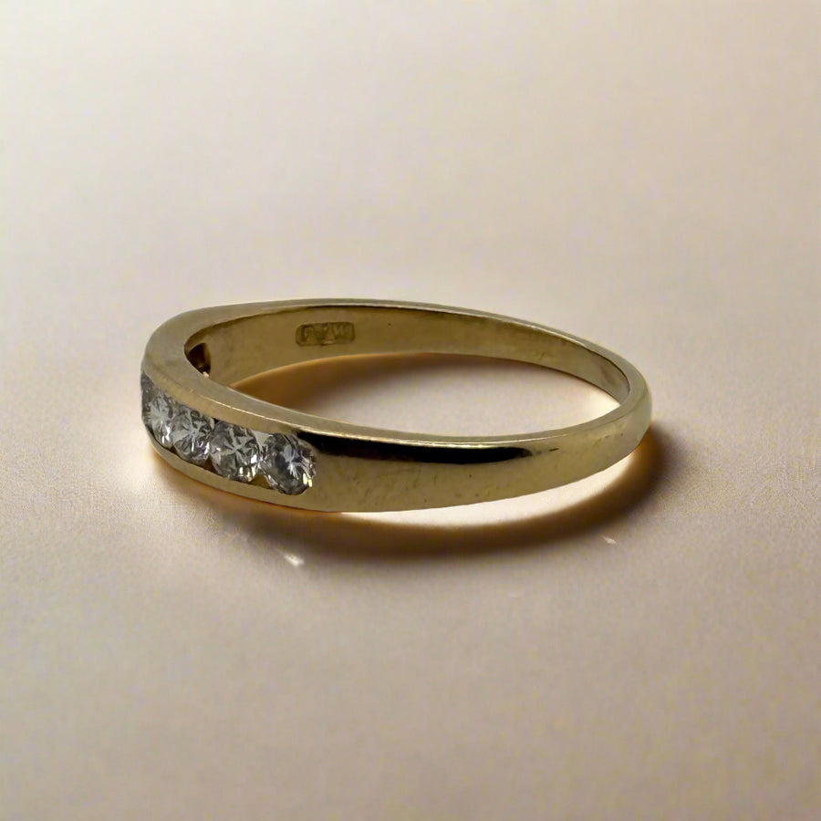 Gold ring with small diamonds on a light gray background