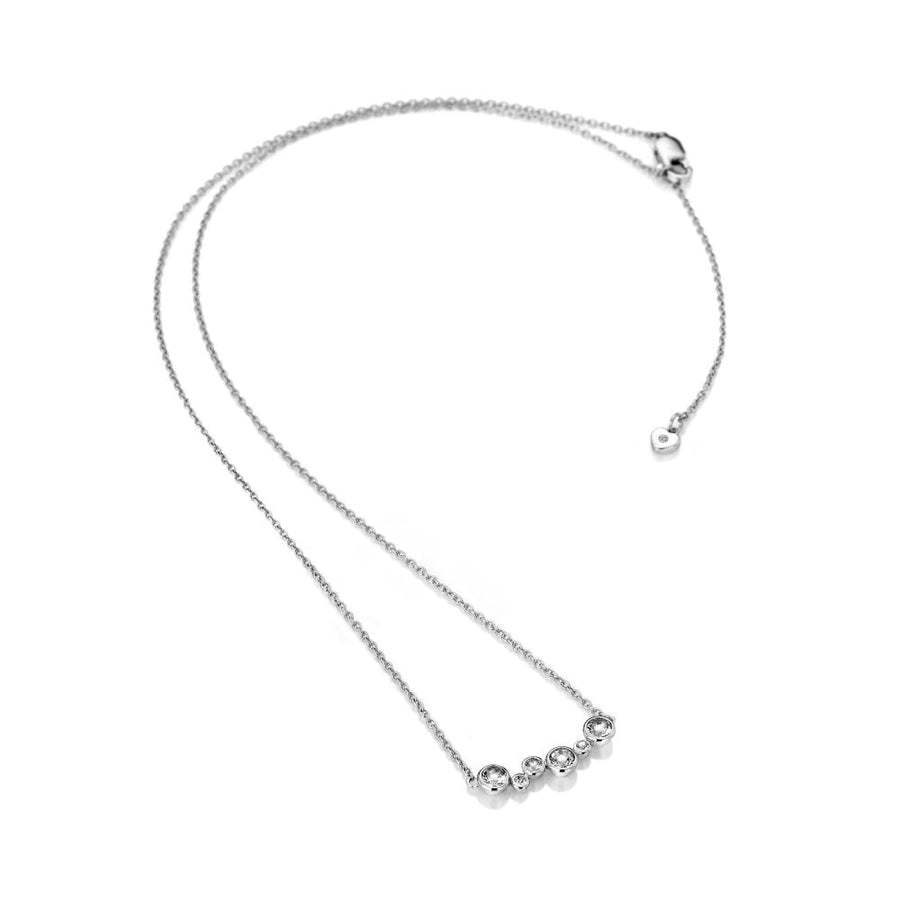 Silver necklace with six small round clear stones on a white background