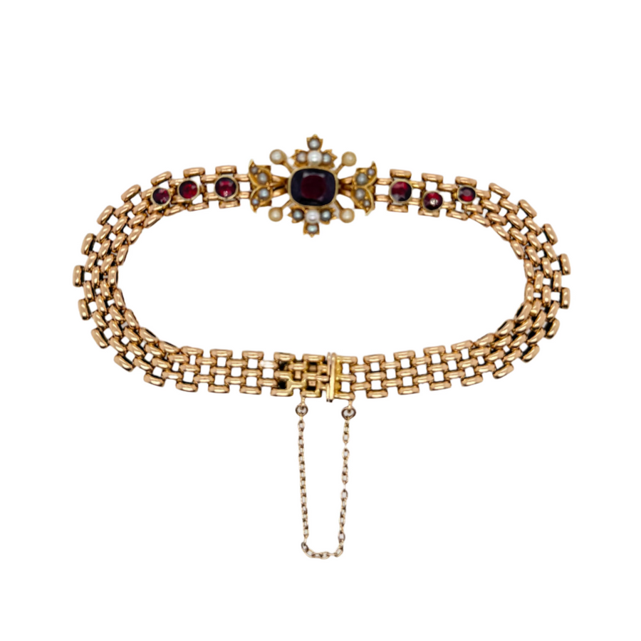 Gold necklace with red stones on a white display box