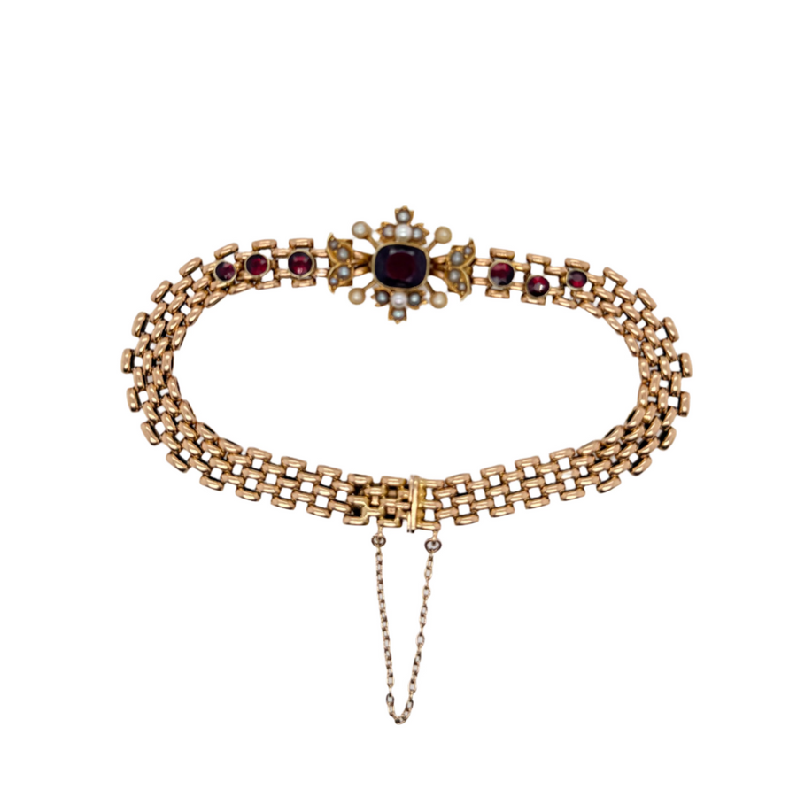 Gold necklace with red gemstones on a white background