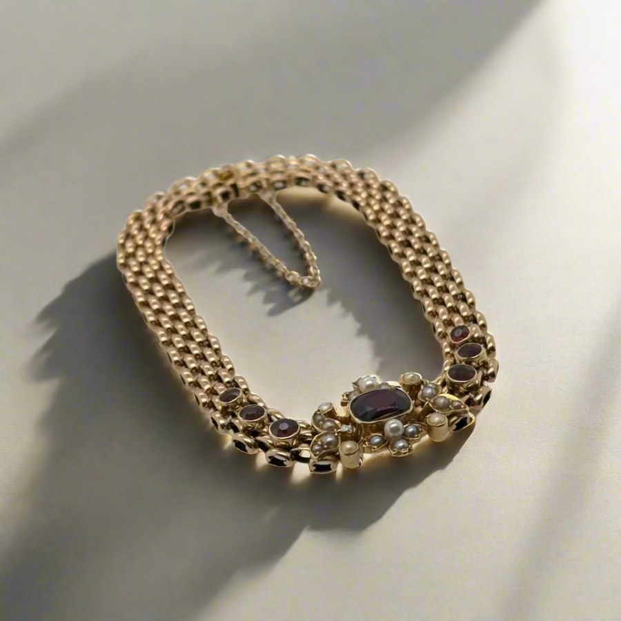 Gold necklace with gemstones on a white surface