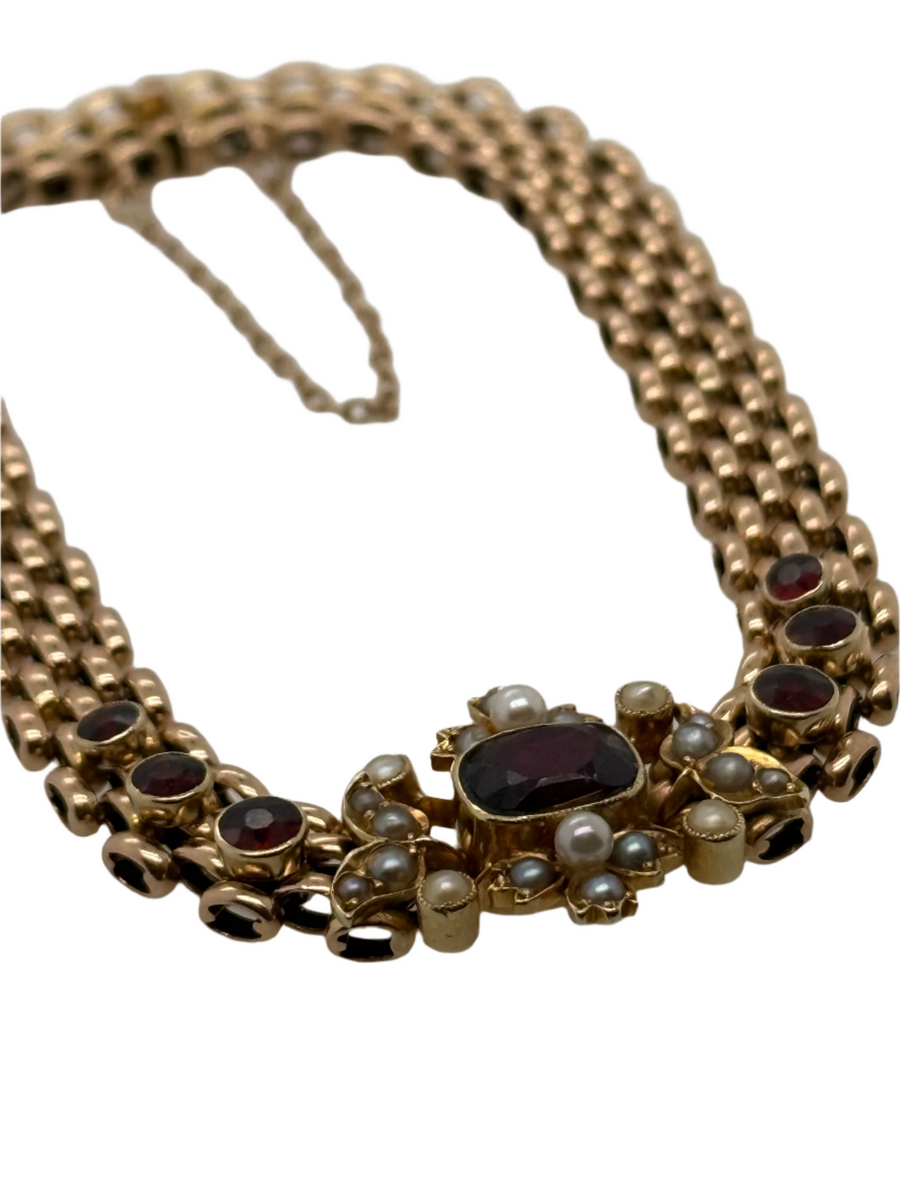 Gold necklace with gemstones and pearls on a white background